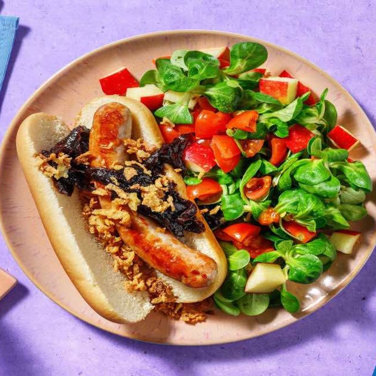 Broodje worst met gebakken uitjes met een salade van appel en tomaat