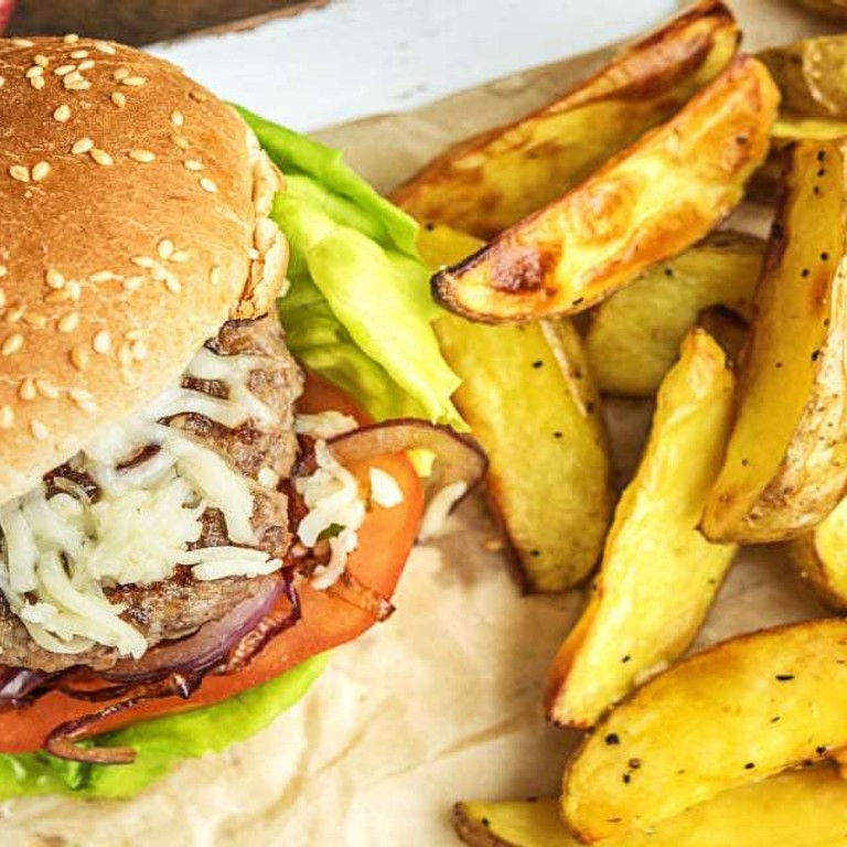 Cheeseburger met tomaat en cheddar Met gebakken aardappeltjes en mayonaise