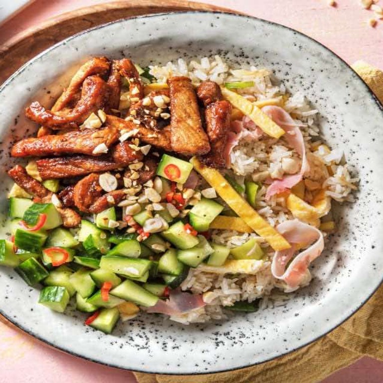 Gemarineerde varkenshaasreepjes met gebakken rijst met ham, omelet en pittige zoetzure komkommer