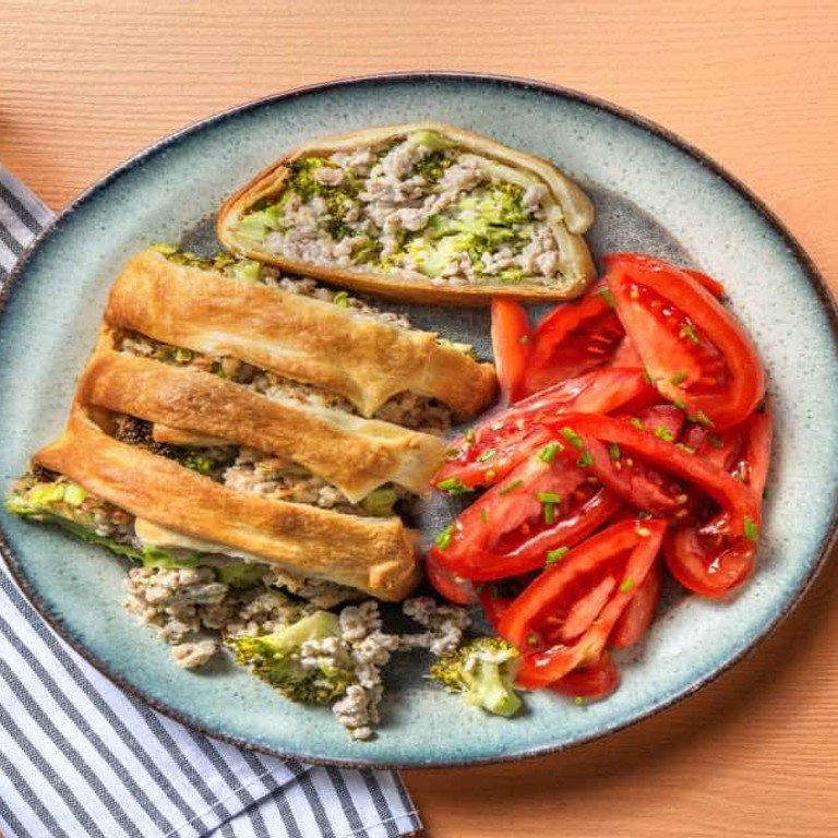 Gevuld bladerdeeg met kipgehakt en broccoli met kruidenroomkaas en tomatensalade