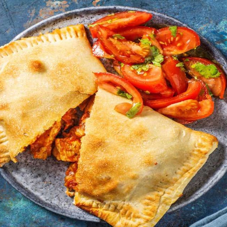 Kip-empanada met cheddar met tomaten-koriandersalade