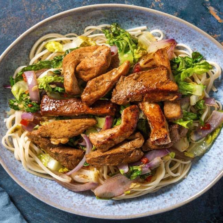 Noedelsalade met varkenshaaspuntjes met rode peper en gebakken romaine sla