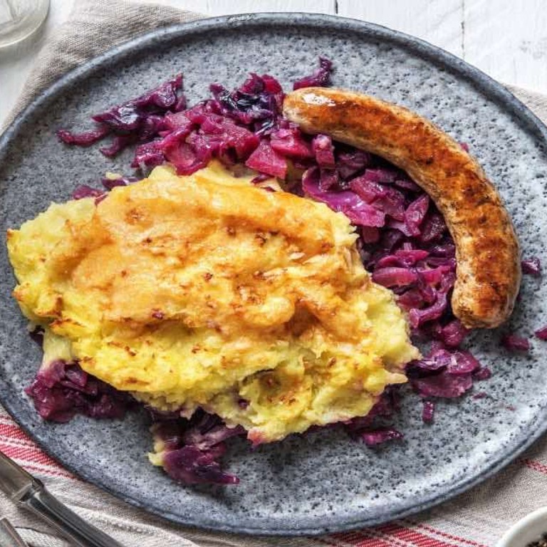 Ovenschotel van rodekool met kipworst met appel en aardappelpuree