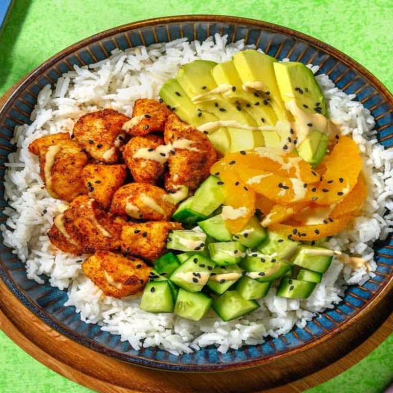 Poke bowl met gefrituurde kip met avocado, sinaasappel, komkommer