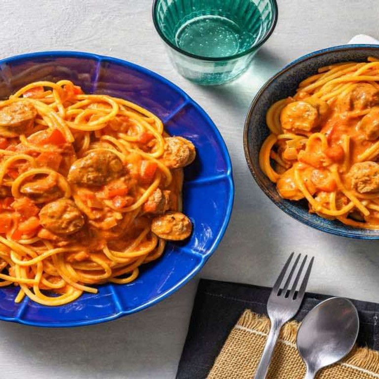 Spaghetti met kipworst en rode pesto in een romige tomatensaus met paprika en tomaat