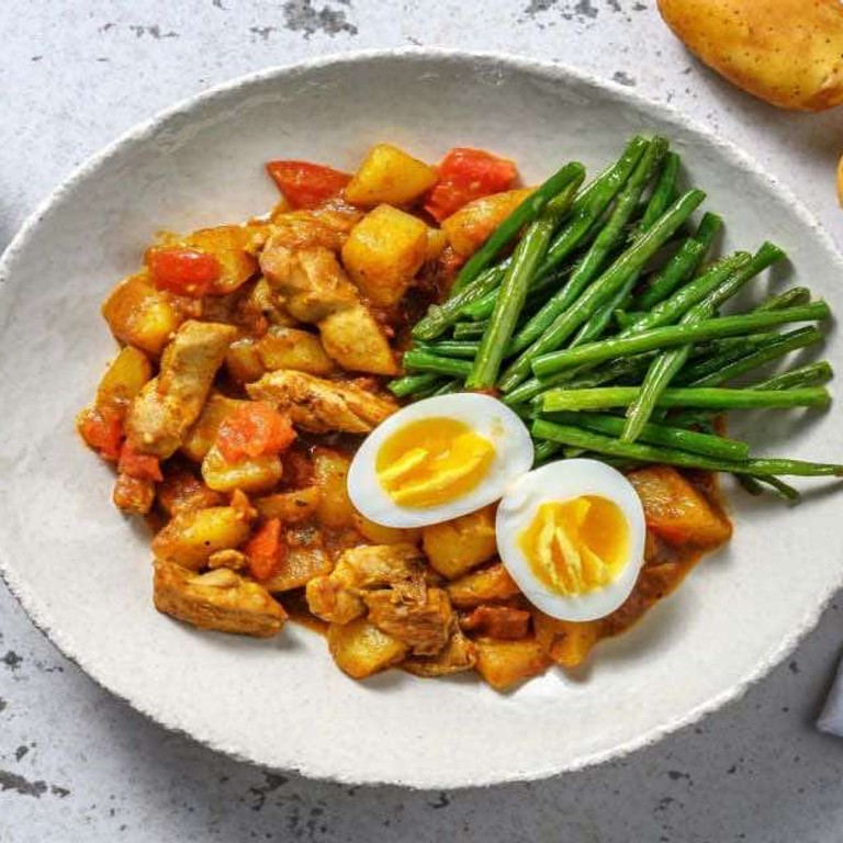 Surinaams gekruide pittige kippendij en aardappel met ei en sperziebonen